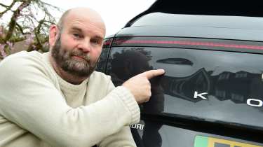 Auto Express creative director Darren Wilson pointing at the Hyundai Kona Electric&#039;s dented tailgate